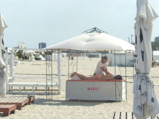Turiştii se relaxează în septembrie cu un masaj, pe plaja din Mamaia